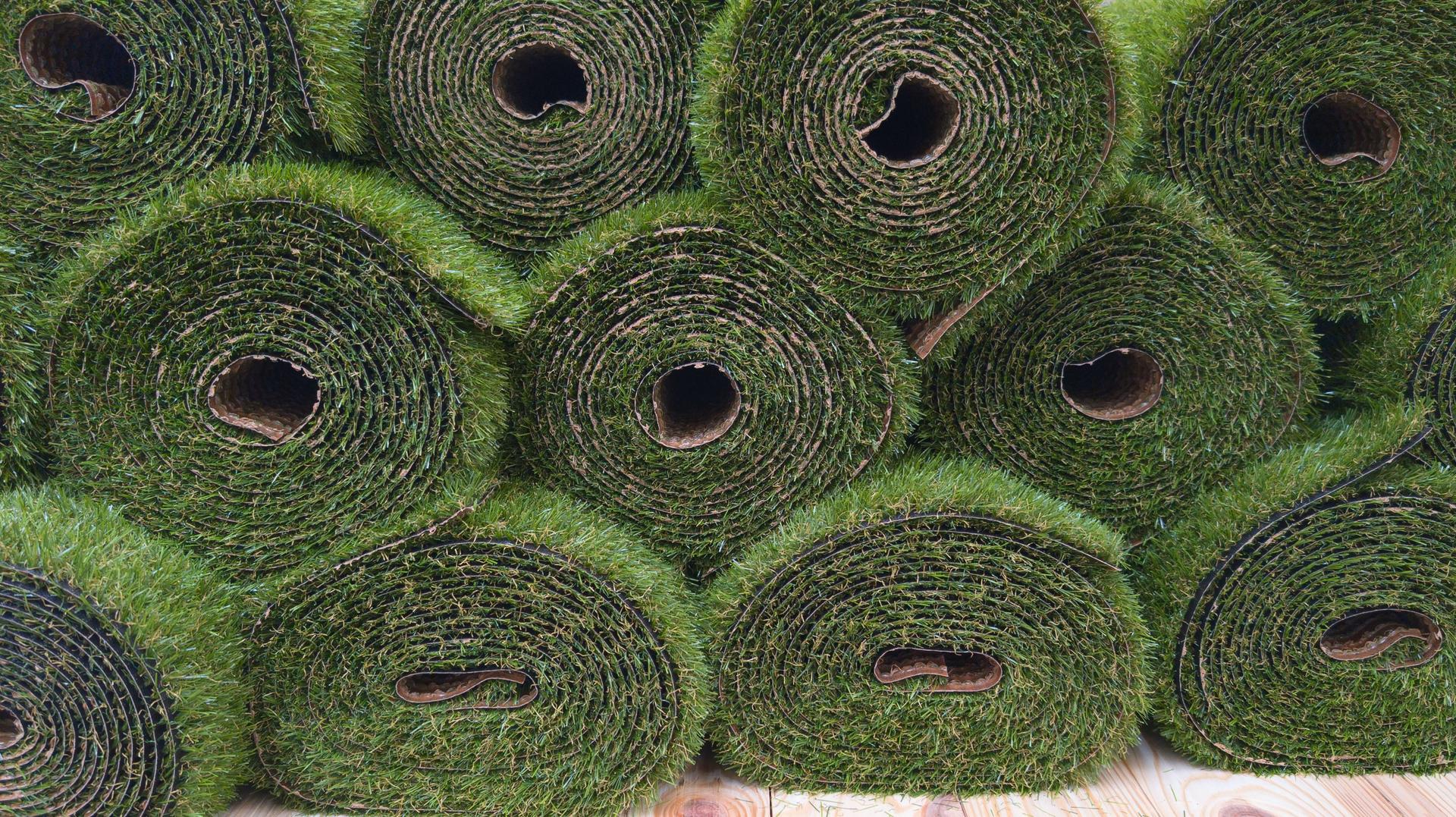 rolled section of vibrant green artificial grass background surface texture color for outdoor floor